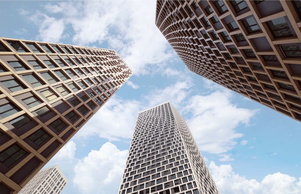 High-rise residential towers seen from below against the sky, with a grid pattern of windows