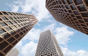 High-rise residential towers seen from below against the sky, with a grid pattern of windows