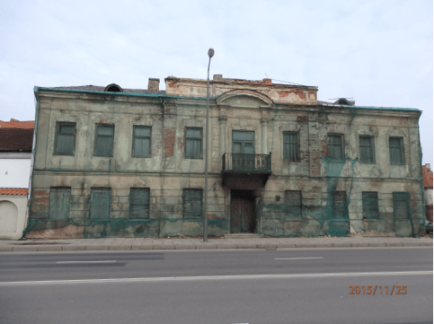 Weathered historic building facade with oxidized plaster finish and regular window openings before renovation